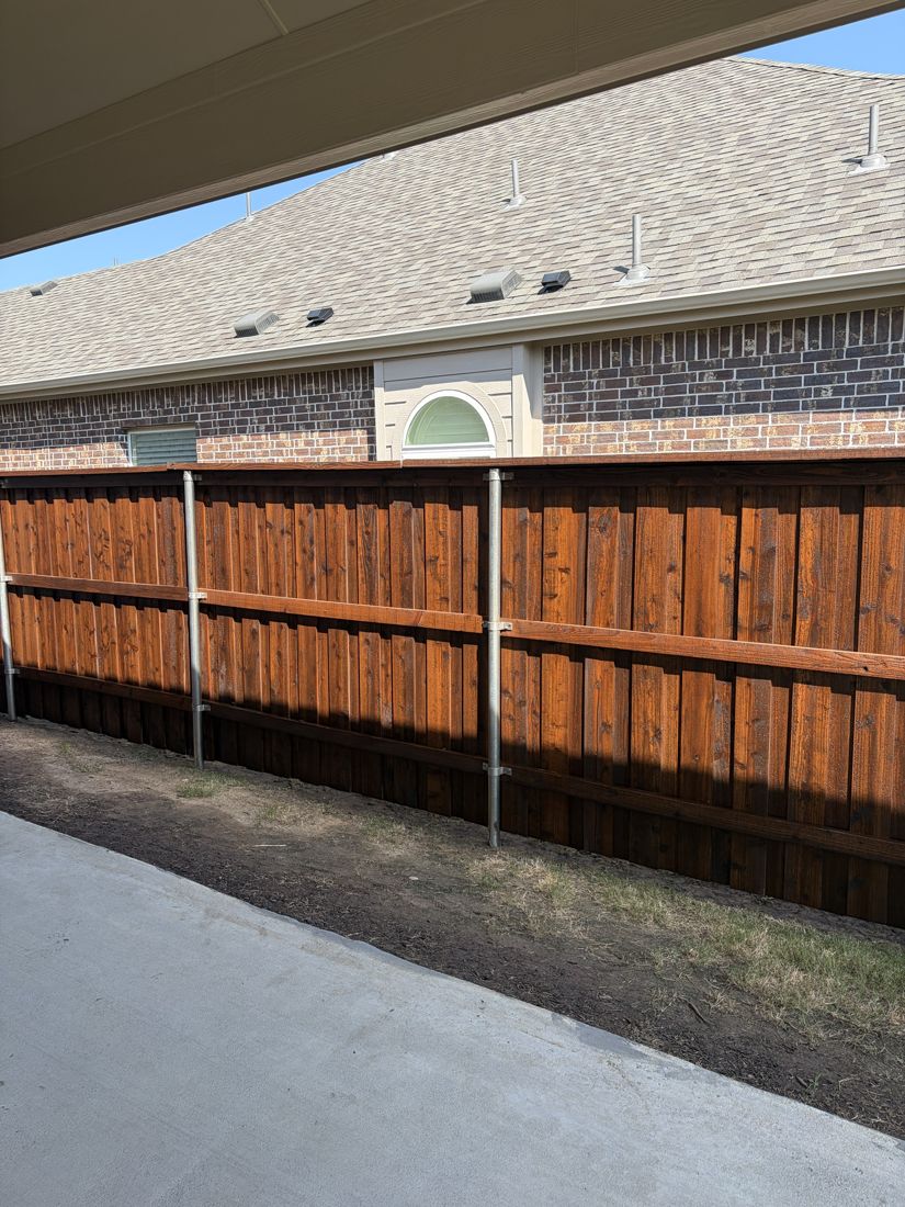 Cedar fence with steel posts stained a warm orange-brown